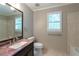 Well-lit bathroom with a granite countertop vanity and window at 3394 Floral Ct, Suwanee, GA 30024