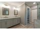 Elegant bathroom features a double vanity, marble counters, a walk-in shower, and shiplap accents at 3394 Floral Ct, Suwanee, GA 30024