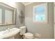 Charming powder room with pedestal sink, decorative mirror, and window with shutters at 3394 Floral Ct, Suwanee, GA 30024