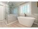 Beautiful bathroom showcasing freestanding tub, glass shower, marble tile, and plantation shutters at 3394 Floral Ct, Suwanee, GA 30024