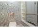 Chic powder room with gray patterned tile wall, toilet, and custom cabinet with open shelf display at 3394 Floral Ct, Suwanee, GA 30024