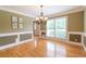 Dining room features a large window, elegant chandelier, hardwood floors, and neutral color scheme at 3394 Floral Ct, Suwanee, GA 30024