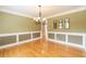 Bright dining room features an elegant chandelier and detailed wainscoting at 3394 Floral Ct, Suwanee, GA 30024