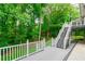 Stairway leading to an exterior deck with white railing and wooded backyard at 3394 Floral Ct, Suwanee, GA 30024