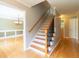 Inviting foyer featuring hardwood floors, elegant staircase with iron railing, and view into the dining room at 3394 Floral Ct, Suwanee, GA 30024