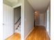 Inviting hallway with hardwood floors, white trim, and a view of the staircase and other rooms at 3394 Floral Ct, Suwanee, GA 30024