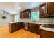 Open-concept kitchen featuring wood cabinets, white countertops, stainless steel appliances, and beautiful hardwood floors at 3394 Floral Ct, Suwanee, GA 30024
