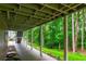 Covered patio with columns, stairway, and view of the wooded backyard at 3394 Floral Ct, Suwanee, GA 30024
