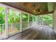 Covered screened porch with wooden ceiling and dark wood flooring, perfect for enjoying outdoor living at 3394 Floral Ct, Suwanee, GA 30024
