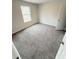 Bright bedroom featuring neutral walls and carpeting, plus a large window at 5518 Legacy Trl, Douglasville, GA 30135