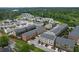 Expansive aerial view of a residential neighborhood featuring modern townhomes with well-manicured landscaping near lush greenery at 6460 Cortland Walk, Alpharetta, GA 30005
