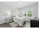 Well-lit bedroom showcasing a bed, large window, bedside tables, and modern decor at 6460 Cortland Walk, Alpharetta, GA 30005