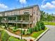 Charming brick townhome featuring a landscaped yard and inviting covered porches for outdoor enjoyment at 6460 Cortland Walk, Alpharetta, GA 30005