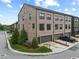 Beautiful brick townhome with a two-car garage, well-maintained lawn, and mature landscaping on a sunny day at 6460 Cortland Walk, Alpharetta, GA 30005