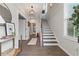 Bright foyer features hardwood floors, staircase with dark treads, natural light, and elegant decor at 6460 Cortland Walk, Alpharetta, GA 30005
