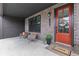 Inviting front porch features brick accents, seating, and an orange front door with a wreath at 6460 Cortland Walk, Alpharetta, GA 30005