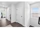 Hallway with wood floors leads to rooms and a window providing natural light at 6460 Cortland Walk, Alpharetta, GA 30005
