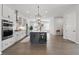 Open kitchen features white cabinets, island with seating, and stainless steel appliances at 6460 Cortland Walk, Alpharetta, GA 30005