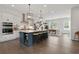 Open-concept kitchen boasts a large island with seating, pendant lighting, and stainless steel appliances at 6460 Cortland Walk, Alpharetta, GA 30005