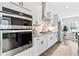 Contemporary kitchen featuring stainless steel appliances, white cabinetry, and hardwood floors at 6460 Cortland Walk, Alpharetta, GA 30005