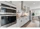 Modern kitchen features white cabinets, stainless steel appliances, and gas cooktop at 6460 Cortland Walk, Alpharetta, GA 30005