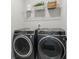 Laundry room features side-by-side washer and dryer under a shelf with decorative accents at 6460 Cortland Walk, Alpharetta, GA 30005