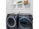 Modern laundry room featuring front loading washer and dryer and a shelf at 6460 Cortland Walk, Alpharetta, GA 30005
