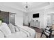 Light-filled main bedroom features a modern TV, chairs, and bathroom access at 6460 Cortland Walk, Alpharetta, GA 30005