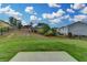 Fenced backyard featuring lush lawn and landscaping under a blue sky with clouds at 1891 Primrose Park Rd, Sugar Hill, GA 30518