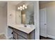 Well-lit bathroom featuring a large mirror and a vanity with gray cabinets at 1891 Primrose Park Rd, Sugar Hill, GA 30518