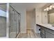 Well-lit bathroom featuring a vanity with gray cabinets and a glass-enclosed shower at 1891 Primrose Park Rd, Sugar Hill, GA 30518