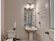 Bathroom featuring pedestal sink, a modern faucet, and a decorative mirror at 1891 Primrose Park Rd, Sugar Hill, GA 30518