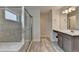 Well-lit bathroom featuring a glass-enclosed shower with bench and a vanity at 1891 Primrose Park Rd, Sugar Hill, GA 30518