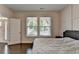Bedroom features hardwood floors, paneled accent wall, and natural light at 1891 Primrose Park Rd, Sugar Hill, GA 30518