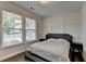 Bright bedroom features large windows, paneled accent wall, and hardwood floors at 1891 Primrose Park Rd, Sugar Hill, GA 30518