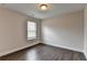 Bedroom with dark hardwood floors, light grey walls, and a window with blinds for natural light at 1891 Primrose Park Rd, Sugar Hill, GA 30518