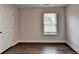 Bedroom featuring dark hardwood floors, natural light from the window, and fresh neutral walls at 1891 Primrose Park Rd, Sugar Hill, GA 30518