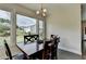 Dining room boasts a chandelier, hardwood floors, and large windows overlooking a backyard at 1891 Primrose Park Rd, Sugar Hill, GA 30518