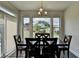 Dining room with hardwood floors, chandelier, and view of the backyard through large windows at 1891 Primrose Park Rd, Sugar Hill, GA 30518
