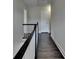 Upstairs hallway featuring wood floors, a staircase, and white trim at 1891 Primrose Park Rd, Sugar Hill, GA 30518