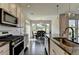 Gourmet kitchen with modern appliances, ample counter space, and a view into the dining area at 1891 Primrose Park Rd, Sugar Hill, GA 30518