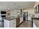 Open-concept kitchen with island, stainless steel appliances, and views into living room and dining area at 1891 Primrose Park Rd, Sugar Hill, GA 30518