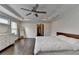 Main bedroom displays hardwood floors, a ceiling fan, a dresser, and a bed at 1891 Primrose Park Rd, Sugar Hill, GA 30518