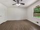 Well-lit bedroom featuring hardwood flooring, ceiling fan, and natural light from the window at 20 Shadow Creek Dr, Villa Rica, GA 30180