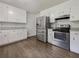Well-lit kitchen features white cabinets, stainless steel appliances, and durable flooring at 20 Shadow Creek Dr, Villa Rica, GA 30180