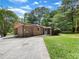 Brick home with a screened-in porch, surrounded by mature trees and a well-maintained yard at 20 Shadow Creek Dr, Villa Rica, GA 30180