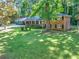 Beautifully landscaped front yard of a brick two-story home featuring a well-manicured lawn and mature trees at 2648 Oswood Dr, Tucker, GA 30084