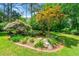 Lush backyard with decorative pond, natural landscaping, and patio seating area for relaxing and entertaining at 312 Crabapple Springs Way, Woodstock, GA 30188