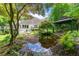 Backyard featuring serene pond, deck, covered gazebo, and mature landscaping, creating a peaceful outdoor retreat at 312 Crabapple Springs Way, Woodstock, GA 30188