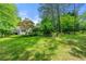 Expansive backyard with large lawn, mature trees, deck, and landscaped areas, perfect for outdoor living at 312 Crabapple Springs Way, Woodstock, GA 30188